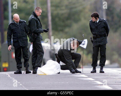 Police officers examine the front of Castlewellan Royal Ulster Constabulary station, where a bomb exploded, seriously injuring one RUC officer. Dissident republicans are being blamed for the bomb attack, which came hours after two Protestants were shot dead. *... in north Belfast in separate attacks. Stock Photo