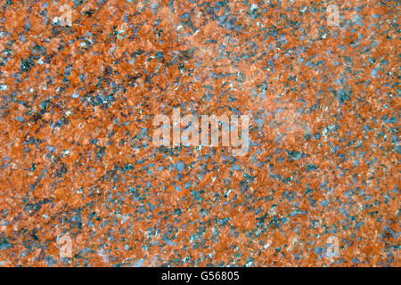 Surface of the wall made of dark granite with brown, gray and white patches. Stock Photo
