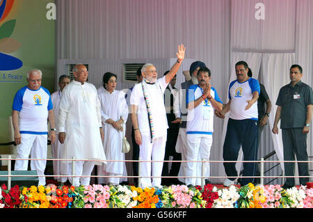 Chandigarh, Punjab, India. 21st June, 2016. Indian Prime Minister Narendra Modi greets well-wishers as he joins thousands of participants during a mass Yoga demonstration during the 2nd International Day of Yoga at the Capitol Complex June 21, 2016 in Chandigarh, Punjab, India. Standing with Modi are the Governor of Punjab Kaptan Singh Solanki, Punjab Chief Minister Prakash Singh Badal, Haryana Chief Minister Manohar Lal Khattar. Credit:  Planetpix/Alamy Live News Stock Photo