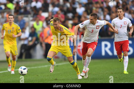Marseille, France. 21st June, 2016. Ukraine's Andriy Yarmolenko (L) and Poland's Artur Jedrzejczyk challenge for the ball during the UEFA Euro 2016 Group C preliminary round soccer match between Ukraine and Poland at the Stade Velodrome stadium in Marseille, France, 21 June 2016. Photo: Federico Gambarini/dpa/Alamy Live News Stock Photo