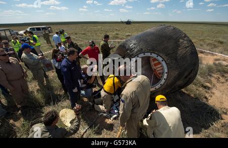 Russian supporter personnel gather around the Soyuz TMA-19M spacecraft to assist the International Space Station Expedition 47 crew moments after landing in the Russian in a remote area June 18, 2016 near Zhezkazgan, Kazakhstan. Stock Photo
