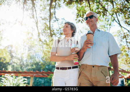 Portrait of senior tourists walking through a park. Mature couple on a summer vacation. Stock Photo