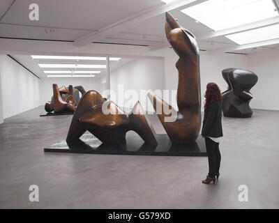 Gallery visitor Phoebe Moore looks at artist Henry Moore's Two Piece Reclining Figure:Cut 1979-81, which is part of the late artist's Late Large Forms exhibition at the Gagosian Gallery in London. Stock Photo