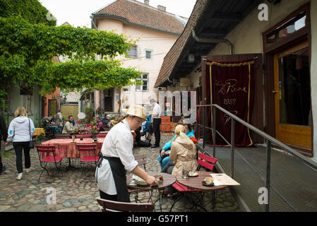 TALLINN, ESTONIA- JUNE 12, 2016: Clients and waiters in a street cafe in the center of Tallinn Stock Photo