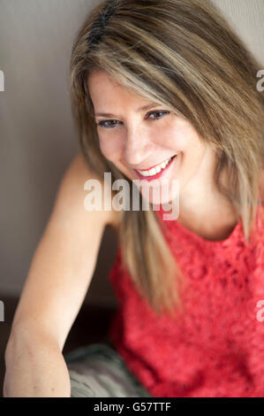 Close up attractive blond 50 year old woman looking away from the camera with toothy smile. Stock Photo