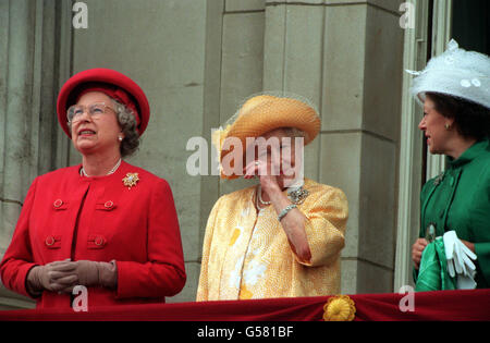 VE DAY 1995: The Queen Mother wipes her eye as she stands on the balcony of Buckingham Palace to greet the thousands of people who had gathered to commemorate the 50th anniversary of VE Day (Victory in Europe Day). Beside her are her daughters, the Queen (left) and Princess Margaret. Stock Photo