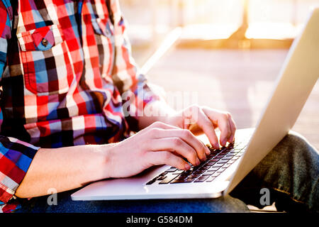 Businessman working from home on laptop, sitting on balcony Stock Photo