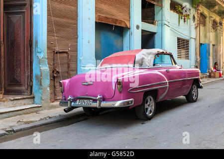 Havana street scene - American classic car, a 1950s Chevrolet Bel-Air convertible in pink, parked in La Habana Vieja, Cuba Stock Photo