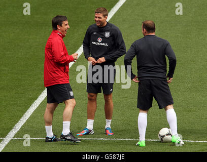 England's Steven Gerrard (centre) shares a joke with coach Gary Neville (left) and Wayne Rooney (right) during a training session at Wembley Stadium ahead of the International friendly match against Belgium Stock Photo