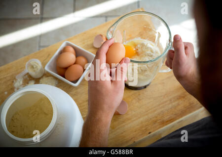Over the shoulder view of a young man making a protein shake. Stock Photo