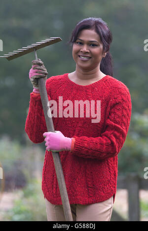 Portrait of a female in an allotment with a rake. Stock Photo