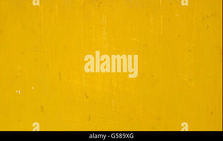 Rusty old metal surface painted in a dirty deep yellow color Stock Photo