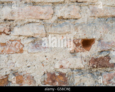 Vintage grunge uneven red brick wall with sprinkled white plaster texture background Stock Photo