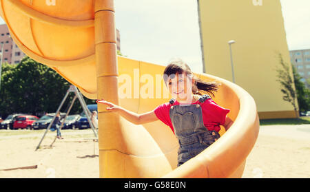 happy little girl on slide at children playground Stock Photo