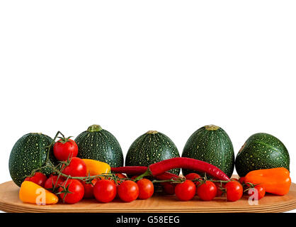 Selection of eight ball zucchini, cherry tomatoes, chili peppers and yellow, orange and red peppers on a wooden board isolated o Stock Photo