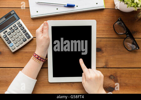 close up of woman with tablet pc on wooden table Stock Photo