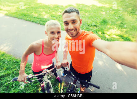 couple with bicycle taking selfie outdoors Stock Photo
