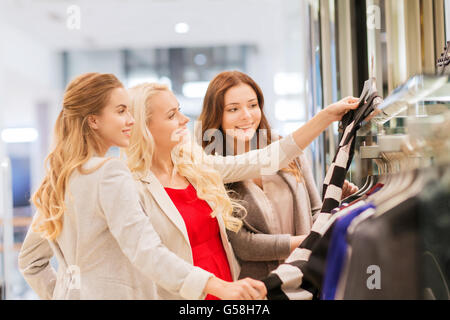 happy young women choosing clothes in mall Stock Photo