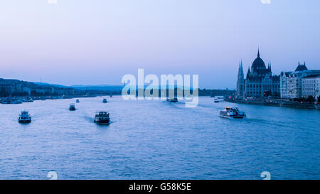 Boats on Danube river near Budapest parliament building at sunset Stock Photo