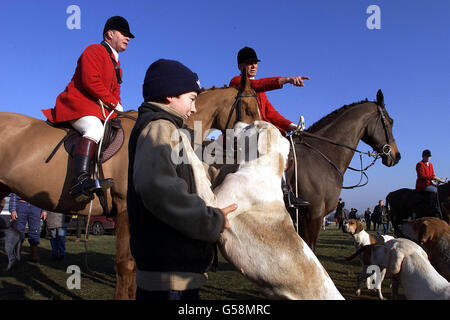 David Trotman, huntsman for the Essex and Suffolk Hunt looks on as his son Chris, 10, greets the hounds at Higham, Suffolk. MPs will vote in the Commons this evening on whether to outlaw hunting with hounds. *...Riders from Essex, Suffolk, Norfolk, Cambridgeshire, Bedfordshire and Hertfordshire took part in the hunt. Stock Photo