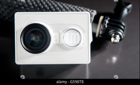 Action camera and small monopod head on black background, selective focus Stock Photo