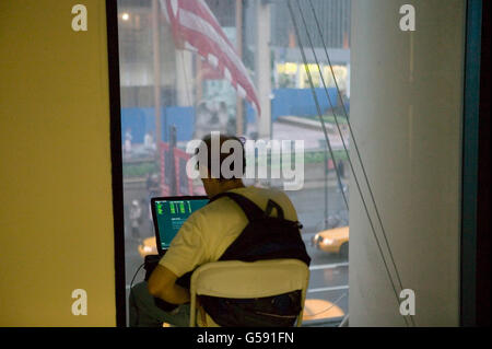 An attendee of the 6th edition of HOPE, an annual hackers' convention, spends time on his laptop, July 22nd 2006, New York City, Stock Photo