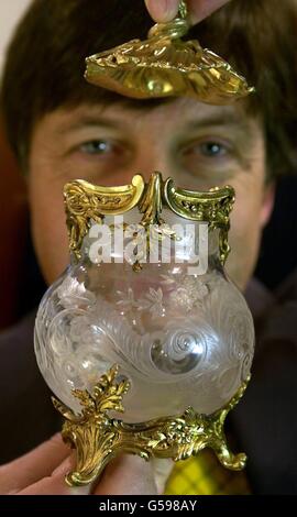 Chairman of Sotheby's South, Tim Wonnacott holds a French silver-gilt mounted intaglio glass vase circa 1880 one of a pair expected to raise between 4000- 6000. *...The vase, unveiled, is one of many antiques Mr Wonnacott discovered in a hidden vault house at Blackburn. The haul is to be auctioned off at Sothebys on and is expected to raise around half a million pounds. Stock Photo