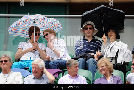Tennis - 2012 Wimbledon Championships - Day One - The All England Lawn Tennis and Croquet Club. Spectators shade from the sun during day one of the 2012 Wimbledon Championships at the All England Lawn Tennis Club, Wimbledon. Stock Photo