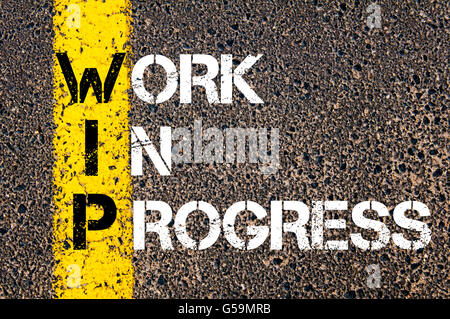Concept image of Business Acronym WIP Work In Progress written over road marking yellow paint line Stock Photo