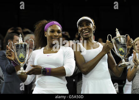 USA's Serena (left) and Venus Williams with their trophies after winning the Ladies Doubles Final during day twelve of the 2012 Wimbledon Championships at the All England Lawn Tennis Club, Wimbledon. Stock Photo