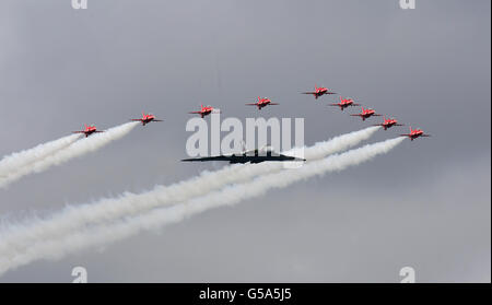 Farnborough International Airshow. The Red Arrows and a Vulcan perform a flypast at the Farnborough International Airshow in Hampshire. Stock Photo