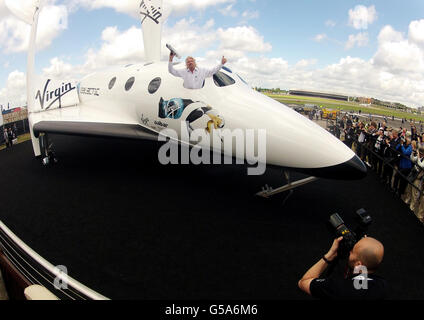 Sir Richard Branson poses for media on his Virgin Galactic Space craft at the Farnborough International Airshow 2012 in Hampshire. Stock Photo