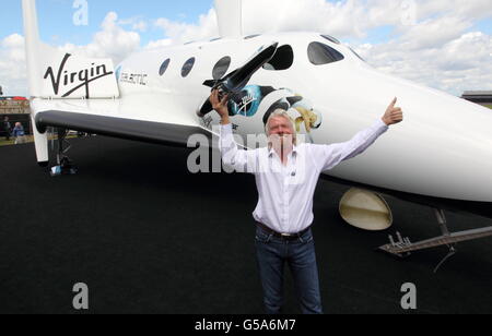 Sir Richard Branson poses for media on his Virgin Galactic Space craft at the Farnborough International Airshow 2012 in Hampshire. Stock Photo