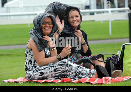 Horse Racing - 2012 John Smiths Northumberland Plate Day - Newcastle Racecourse. Racegoers shelter from a rain shower during the 2012 John Smiths Northumberland Plate Day at Newcastle Racecourse. Stock Photo