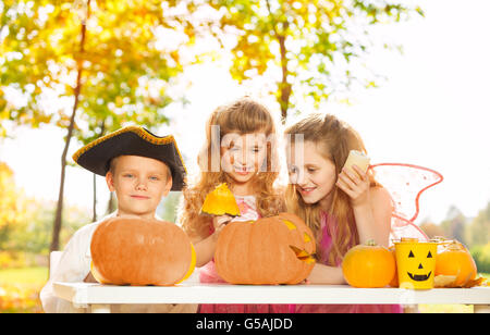 Kids in different costumes craft Halloween pumpkin Stock Photo