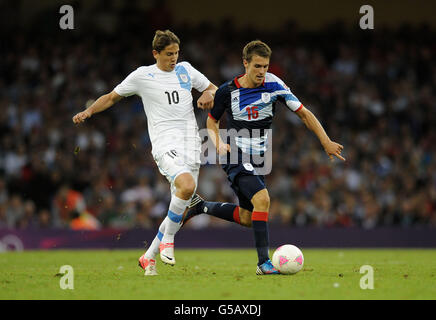 Great Britain's Aaron Ramsey (right) and Uruguay's Gaston Ramirez battle for the ball during the group A match at the Millennium Stadium, Cardiff. Stock Photo