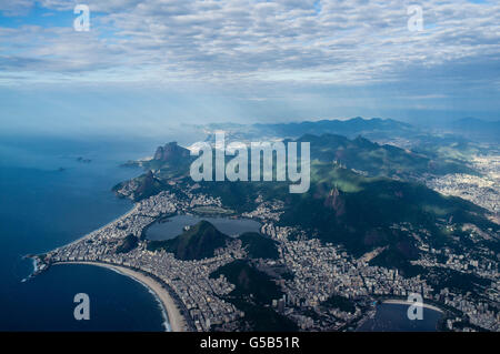 Aerial view of part of Rio de Janeiro south zone - Copacabana beach at left-foreground, Ipanema and Leblon beaches at left-center, Corcovado mountain with its Christ the Redeemer statue at center-right surrounded by Tijuca Forest, Lagoa Rodrigo de Freitas at center and Pedra da Gavea & Barra da Tijuca borough in background. It is the richest region of the city, and is visited by thousands of tourists from different parts of the world throughout the year. Stock Photo