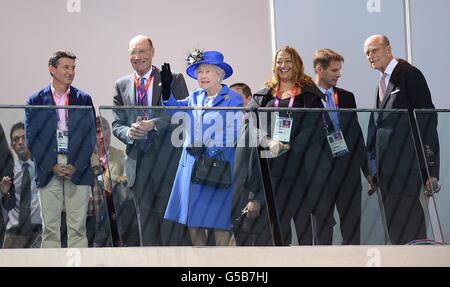 LOCOG Chairman Lord Sebastian Coe (left) watches on as Queen Elizabeth II waves to the crowd during the morning session of the swimming at the Aquatics Centre in London on day one of the London 2012 Olympics. Stock Photo