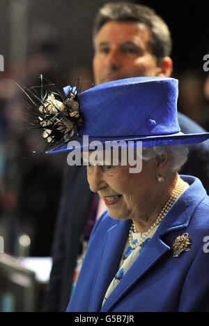 Queen Elizabeth II with LOCOG Chairman Lord Sebastian Coe (partially obscured) at the Aquatics Centre in London on day one of the London 2012 Olympics. Stock Photo