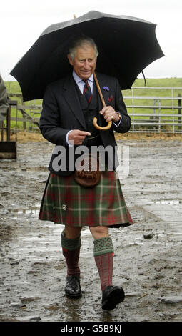 The Prince of Wales shelters from the rain under an umbrella during a visit to Sibster Farm near Wick in Scotland. Stock Photo