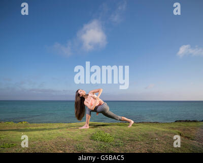 Young woman practicing yoga on the beach in Motobu, Okinawa, Japan Stock Photo