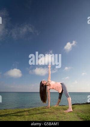 Young woman practicing yoga on the beach in Motobu, Okinawa, Japan Stock Photo