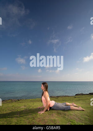 Young woman practicing yoga on the beach in Motobu, Okinawa, Japan Stock Photo
