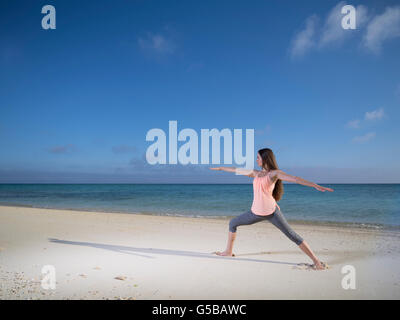 Young woman practicing yoga on the beach in Motobu, Okinawa, Japan Stock Photo