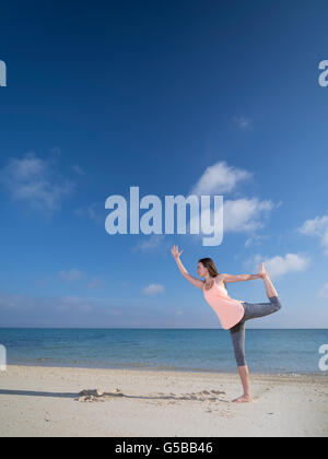 Young woman practicing yoga on the beach in Motobu, Okinawa, Japan Stock Photo