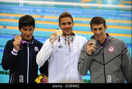 Gold Medalist South Africa's Chad le Clos (centre), Silver Medalist USA's Michael Phelps (right) and Bronze Medalist Japan's Takeshi Matsuda receive their medals after the Men's 200m Butterfly Final at the Aquatics Centre in the Olympic Park during the fourth day of the London 2012 Olympics. Stock Photo