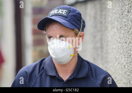 A police officers takes a break from searching through rubbish bins near Tia Sharp's grandmother's home in New Addington, London. Stock Photo