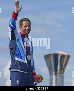 Great Britain's Finn sailor Ben Ainslie celebrates winning his fourth Olympic gold medal at the Sailing venue in Portland. Stock Photo