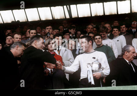 Derby County manager Brian Clough (with assistant Peter Taylor to his left) shakes hands with his captain Dave Mackay as he holds the League Division Two Championship trophy. Stock Photo