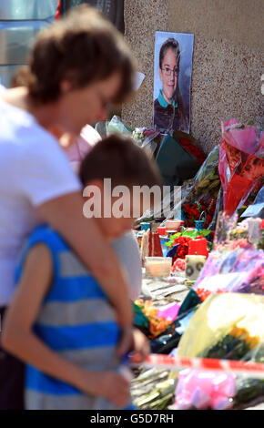 A young boy is comforted by his mother after laying flowers at the make shift memorial to Tia Sharp in New Addington, Croydon, near to the home of the missing 12 year old's grandmother Christine Sharp, where a body was found yesterday. Stock Photo